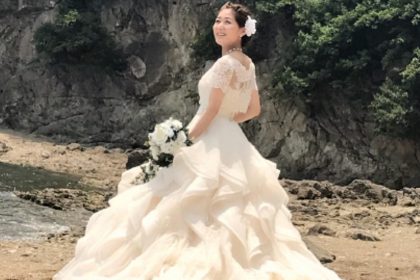 ビーチに立つウェディングドレスを着た花嫁。