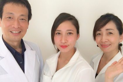 白衣を着たアジア人女性3人が写真にポーズをとっている。
