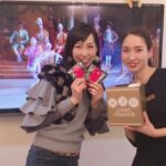 テレビの前に立つ 2 人のアジア人女性。