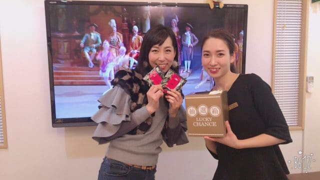 テレビの前に立つ 2 人のアジア人女性。