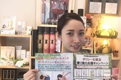 店内でポスターを掲げる女性。