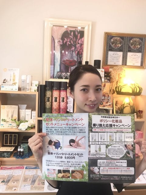 店内でポスターを掲げる女性。