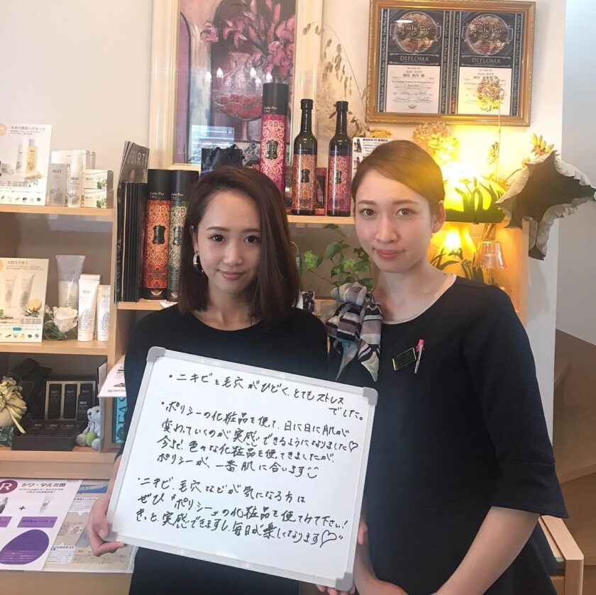 店で看板を掲げる 2 人の日本人女性。