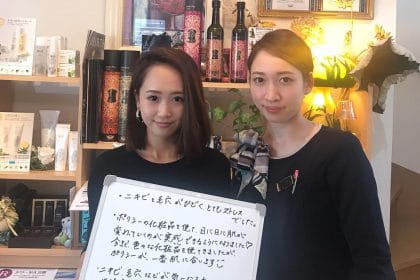 店で看板を掲げる 2 人の日本人女性。