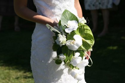 白いドレスを着て花束を持った女性。