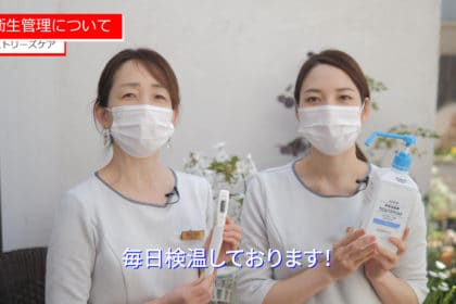 フェイスマスクを着用し、ボトルを保持している 2 人の女性。