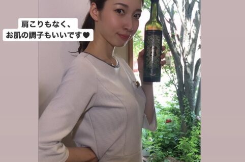 女性がワインのボトルを持っています。