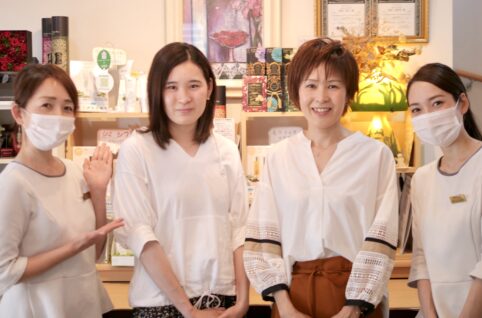 店の前に立つ 4 人のアジア人女性。