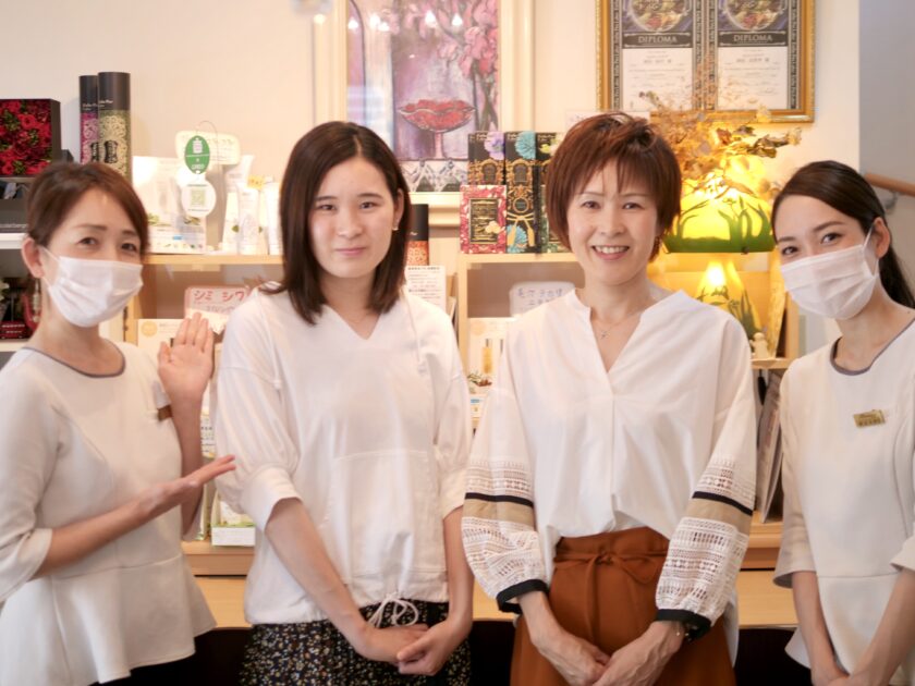 店の前に立つ 4 人のアジア人女性。