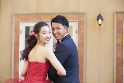 赤いドレスを着て写真を撮る男性と女性。