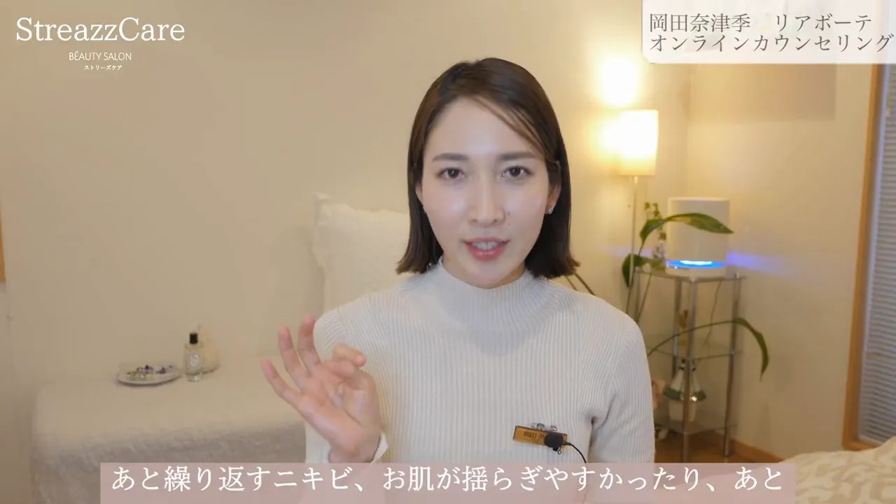 カメラに向かって話し、片手で説明のジェスチャーをしている女性の映像。表情がはっきり見える。